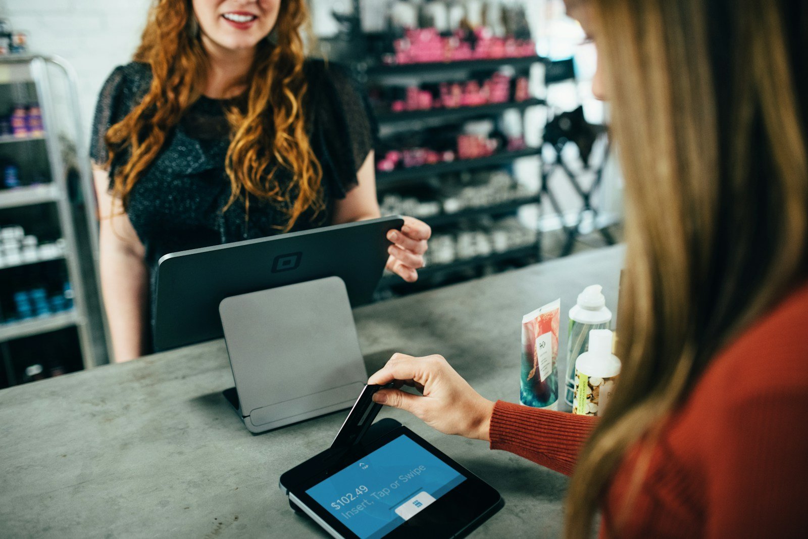 Small shop owner checking orders on a tablet at the counter