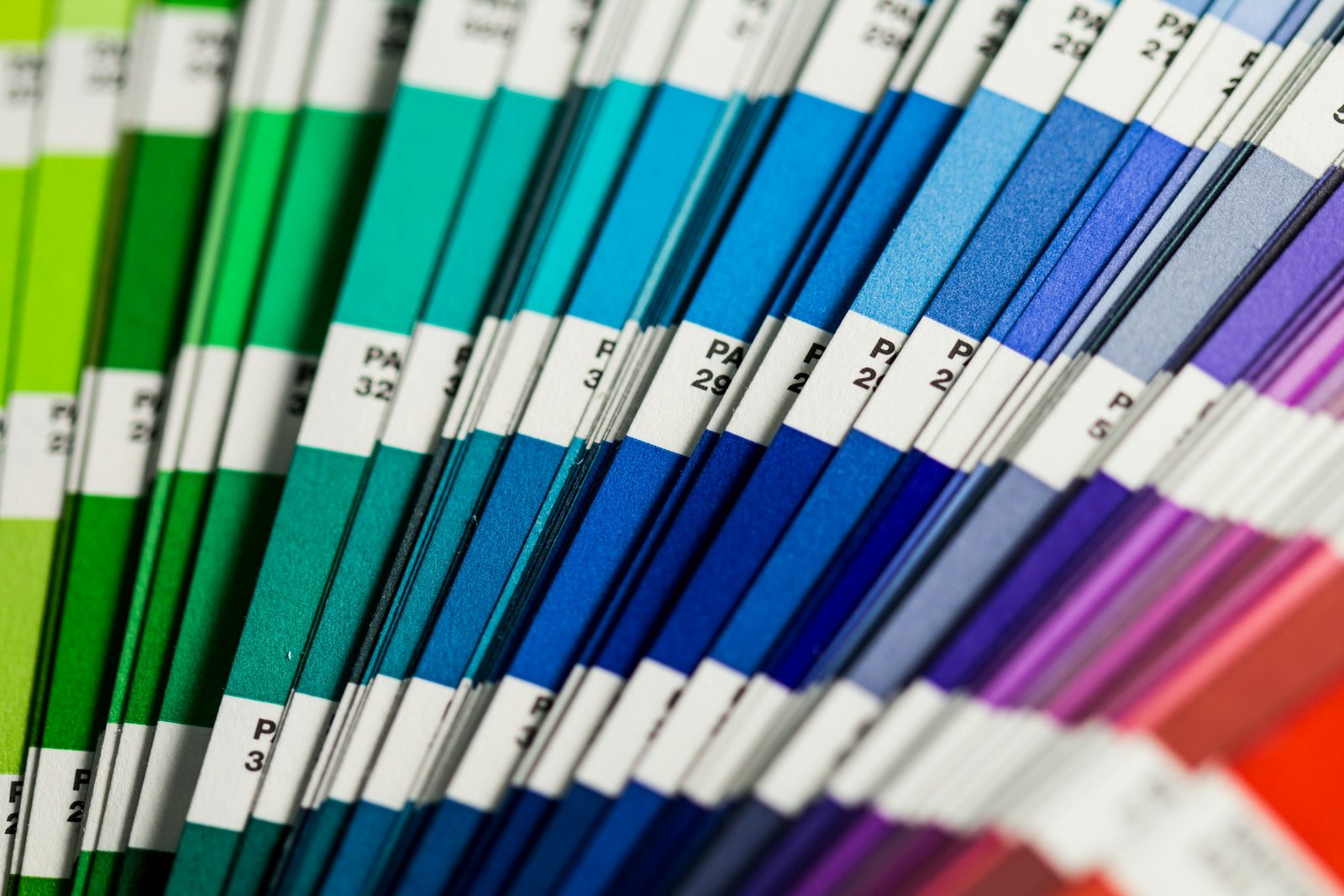 Pantone color swatches fanned out, showing a gradient from green to purple