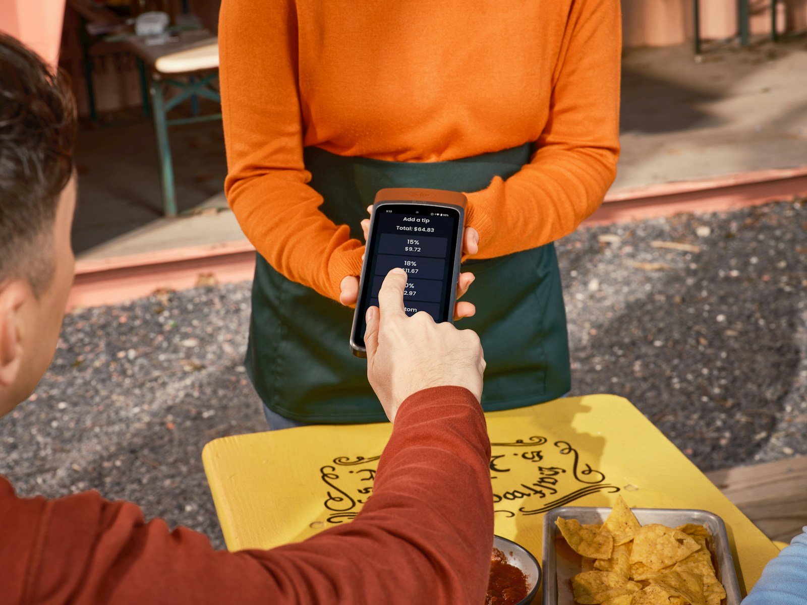 Waiter processing a contactless payment at a restaurant table