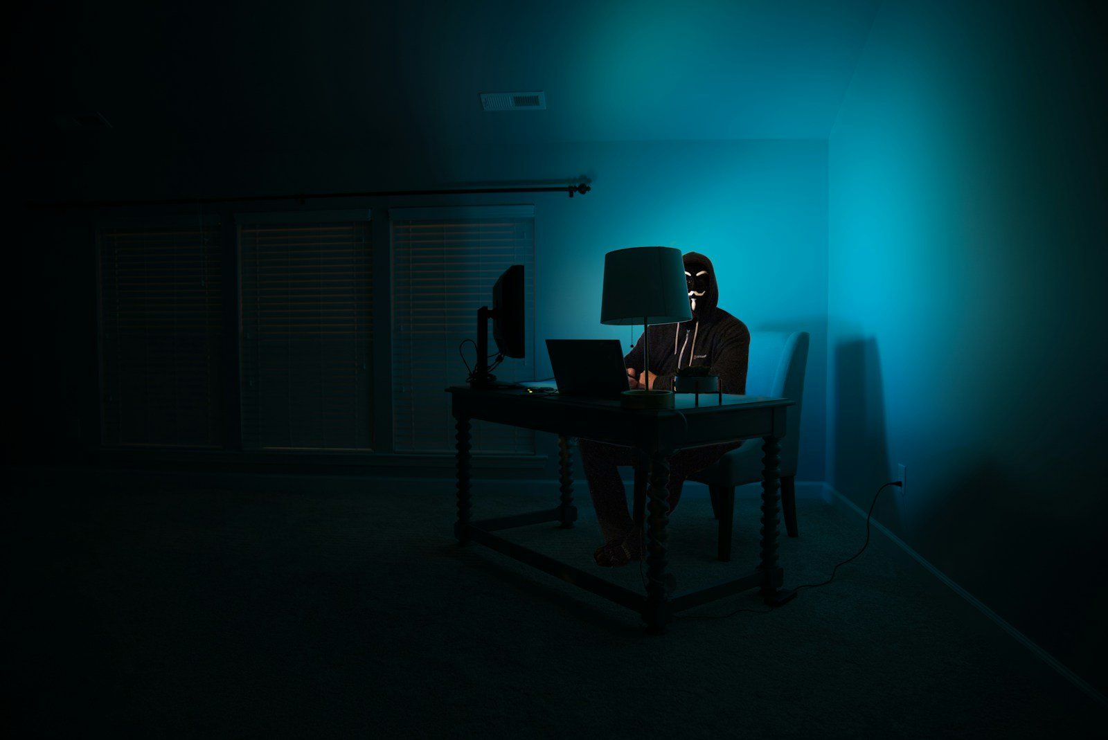 Person viewing a phishing warning on a laptop screen in a dark room