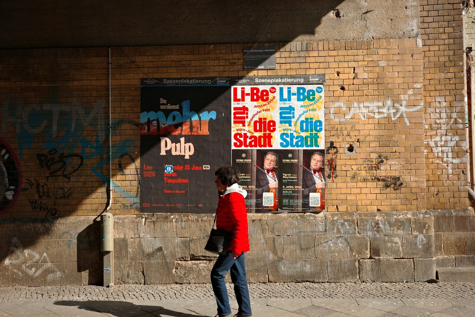 Person scanning a QR code poster on a city street with a smartphone
